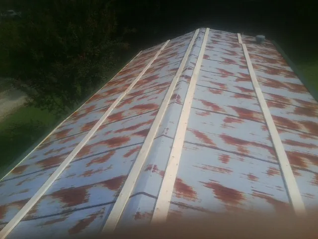 Rusted metal roof panels with new wood purlins before replacement — Storm Damage Roof Repair in Lawler by Roofing Brothers