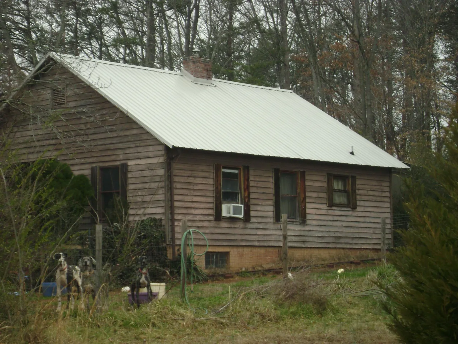 White metal roof on an old wood sided farmhouse, from a Metal Roof Installation job in Lawler